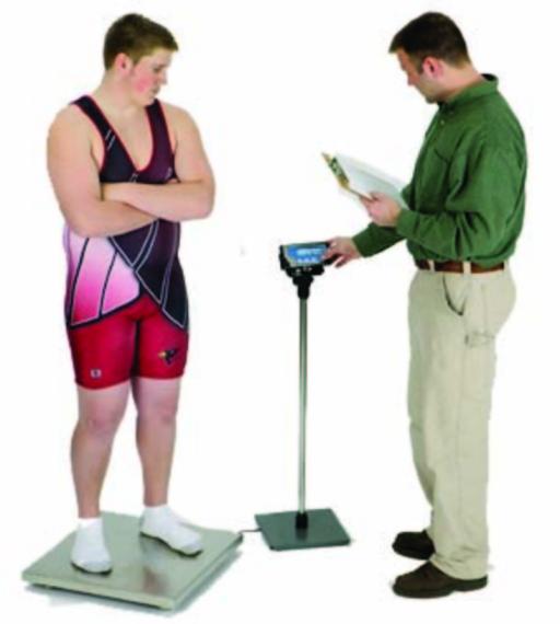 high school student standing on a wrestling weigh-in tournament scale